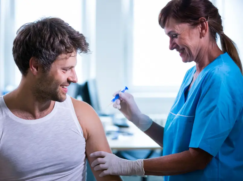 A man receiving a vaccination from a nurse